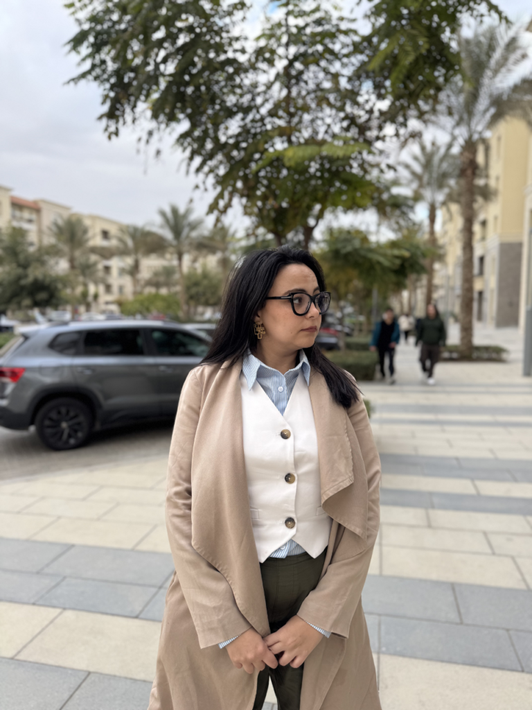 Rahma Ali, digital marketer and life coach, smiling while sitting and looking confidently at the camera.